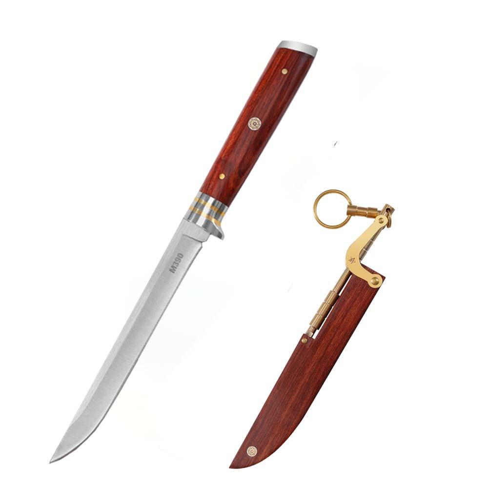 An open M390 folding knife with a wood handle, displayed separately from its wooden sheath with a brass linkage, on a clean white background.