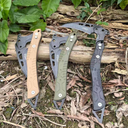 Sand, olive green, and black tactical multi-purpose breaching tools displayed horizontally, clearly showcasing their distinctive curved blades and skeletonized handle design.