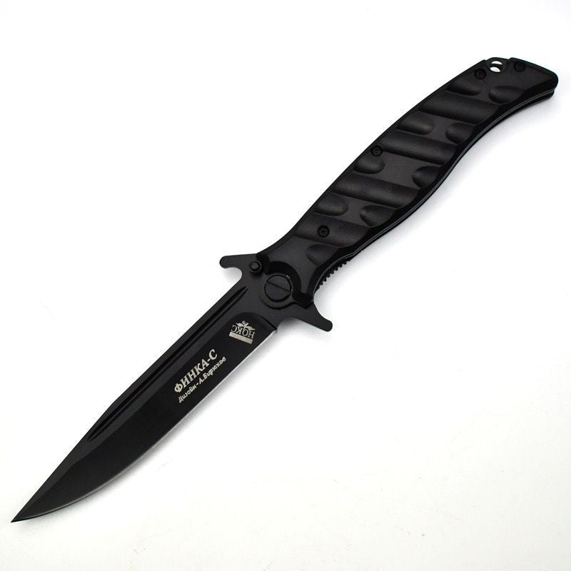 An open Noks folding knife with a black handle and a silver blade, displayed on a white background.