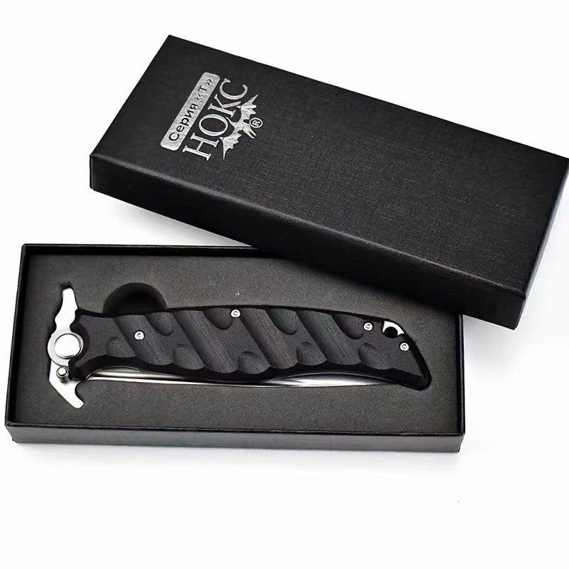 A Noks folding knife inside its black presentation box, displayed on a white background.
