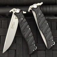 An open and a closed Noks folding knife displayed on a black rope-textured surface, showing the Cyrillic engraving on the blade.