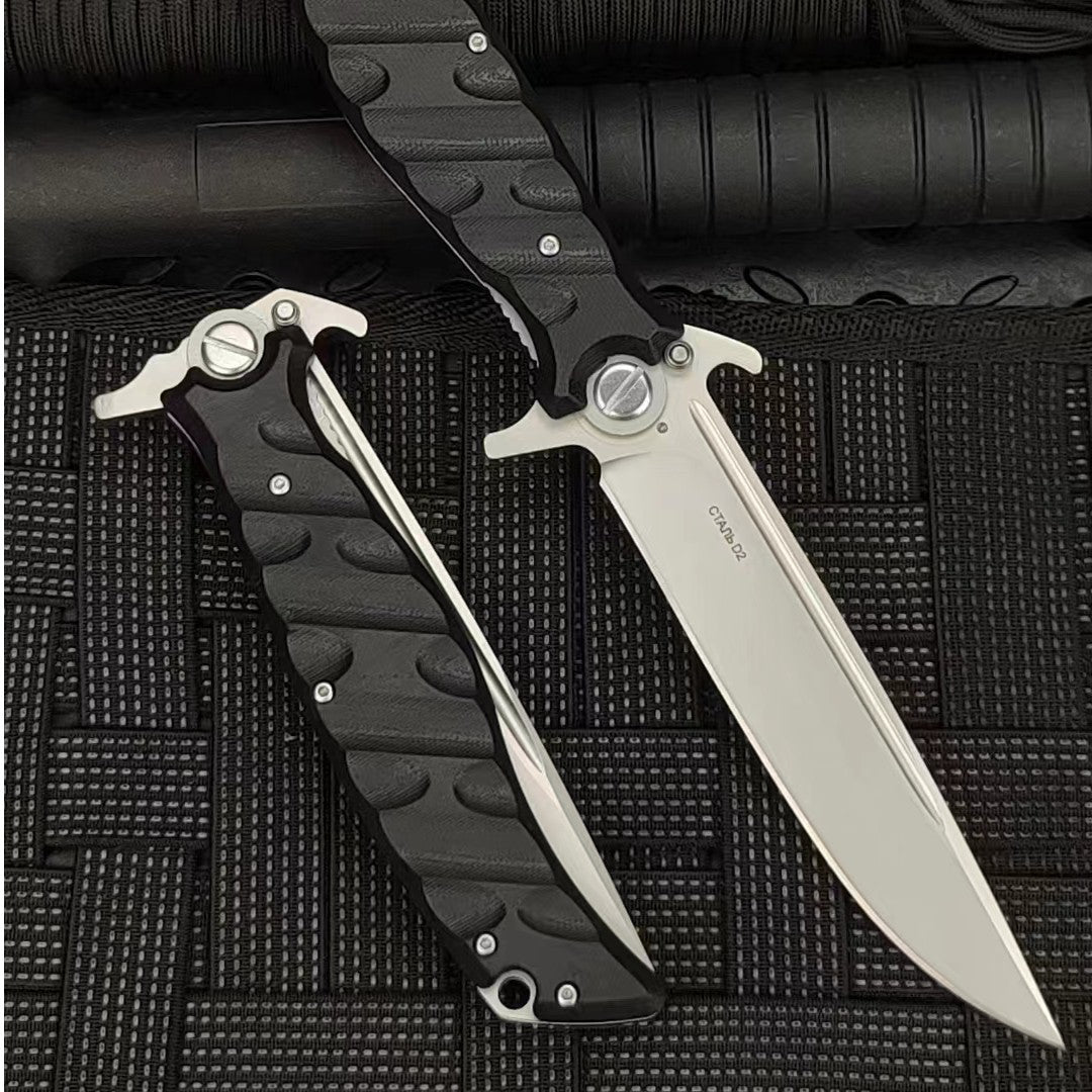 An open and a closed Noks folding knife on a black rope-textured surface, showing the D2 steel marking on the open blade.