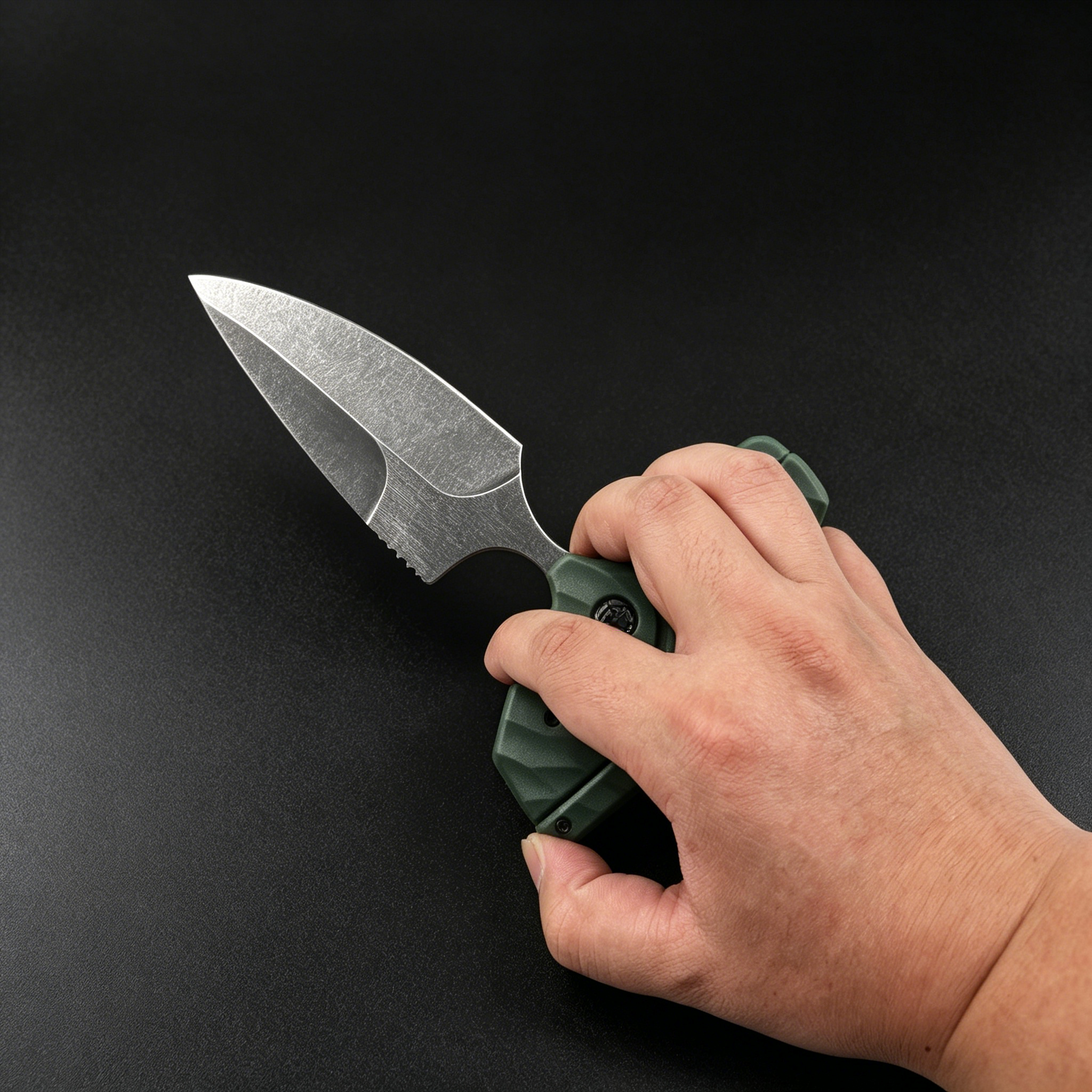 A hand holding an open folding knife with an olive green textured handle and a silver stonewashed blade, displayed against a dark background.