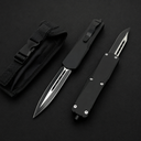 Two black OTF knives with carbon fiber handles and silver blades, displayed next to a black nylon sheath.