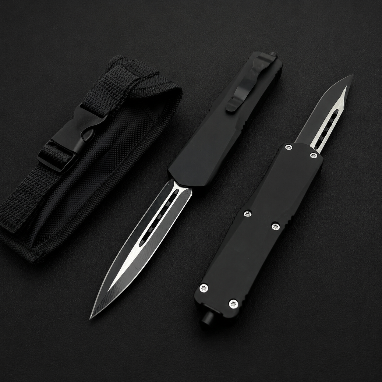 Two black OTF knives with carbon fiber handles and silver blades, displayed next to a black nylon sheath.