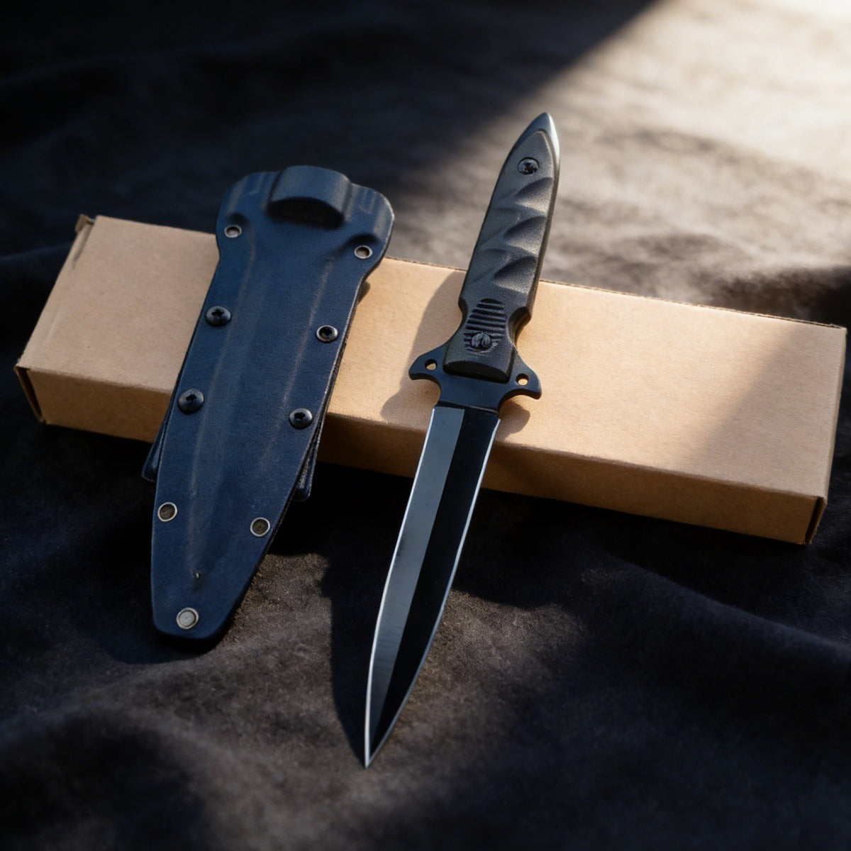 Black tactical double-edged fixed blade knife with an all-black finish, featuring a non-slip cross guard and tactical Kydex sheath, displayed on an outdoor tactical backpack to showcase its rugged outdoor style.