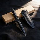 Black tactical double-edged fixed blade knife with an all-black finish, featuring a non-slip cross guard and tactical Kydex sheath, displayed on an outdoor tactical backpack to showcase its rugged outdoor style.