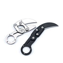 Two open mechanical folding karambit knives, one silver and one black, featuring finger ring handles and articulated arms with visible star screws, displayed on a white background.