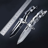 Two open skeletonized Tanto folding knives, one black and one silver, placed next to a metal ruler on a dark background to show their size and length.