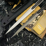 Two slim folding knives, one silver and one black, laid over a black sheath and a digital camo pouch against a rough rocky surface.