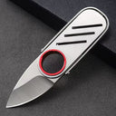 An open slim EDC folding knife with a brushed silver steel body, red finger ring, and three horizontal slots, displayed on a dark background.