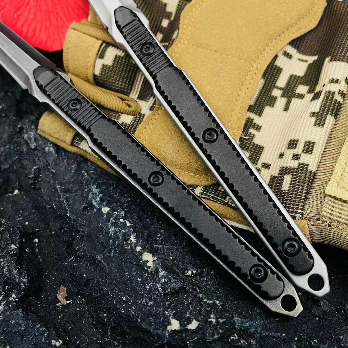 A close-up of two slim tactical folding knife handles, showing the detailed groove textures on the black and silver/grey handles, displayed on a dark rocky surface.