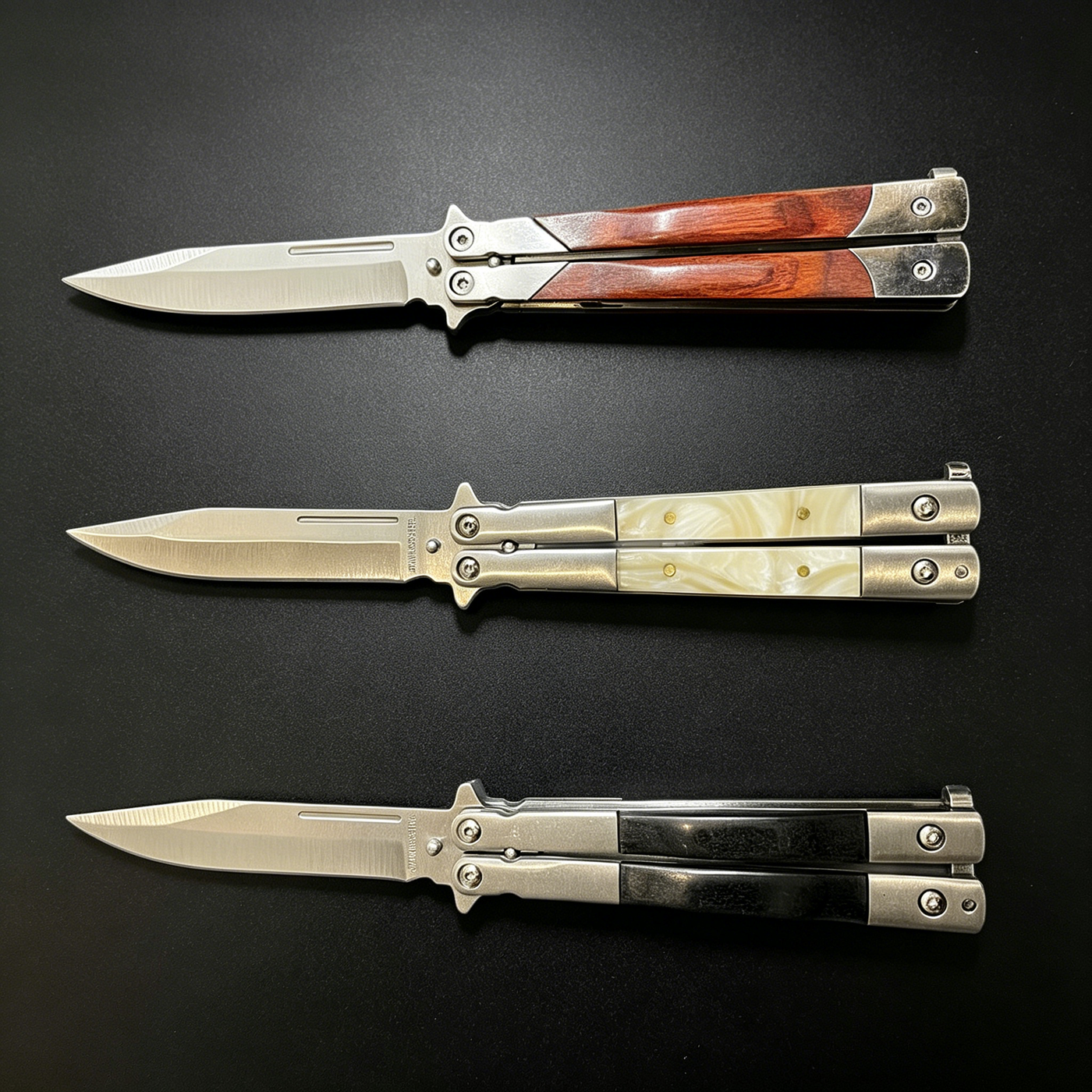 Three open balisong butterfly knives with silver blades and different handle materials: wood, pearl, and black, displayed horizontally on a dark background.