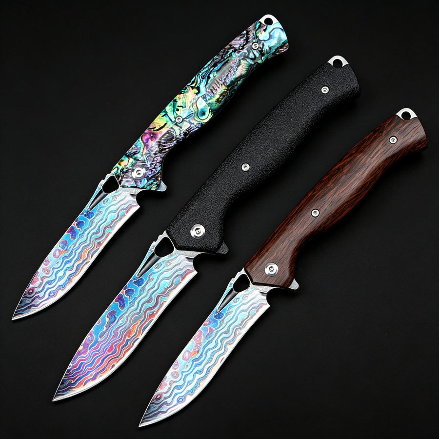 Three different EDC folding knives displayed on a black background, featuring colorful Damascus/Titanium patterned blades and handles in shell, matte black, and dark wood finishes.