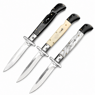 Three open Italian stiletto folding knives with silver blades and crossguards, featuring black, creamy white, and black-and-white marbled handles, displayed on a white background.