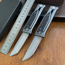 Two tactical folding knives with different blade shapes (tanto and drop point) displayed next to a ruler on a wooden surface.