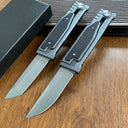 Two tactical folding knives, one with a tanto blade and one with a drop point blade, displayed open on a wooden surface.