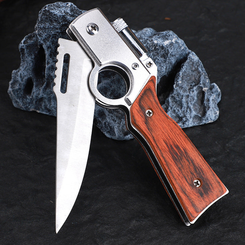 An open folding knife with a wooden handle, silver finger ring frame, and silver blade, displayed on a dark textured stone background.
